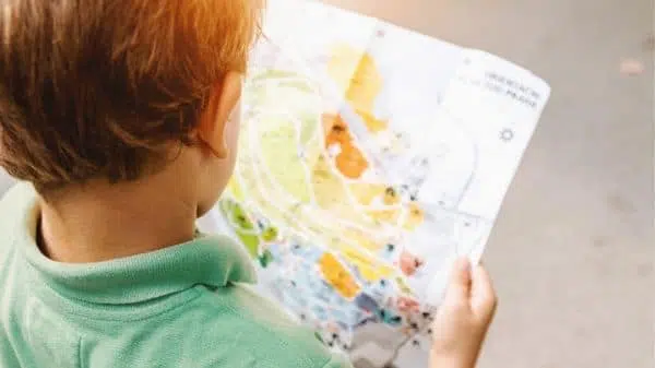 enfant cherchant indices sur plan de jeu de piste
