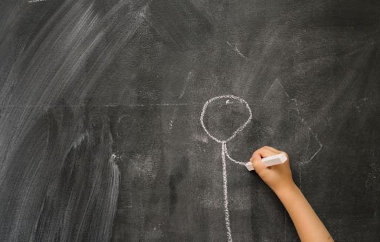main enfant qui dessine à la craie pour dessiner c'est gagné