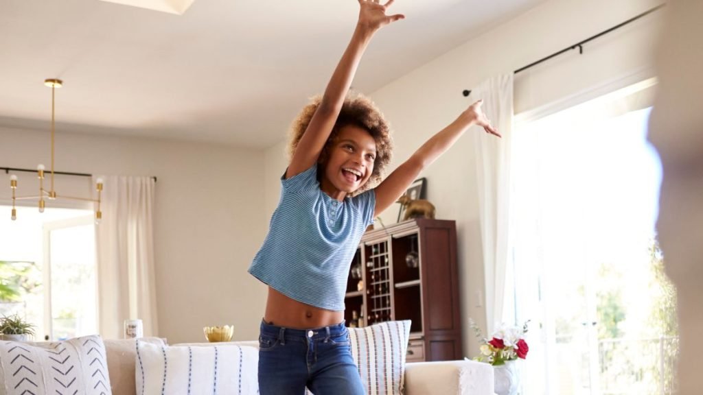 enfant souriant mimant avec les bras en l'air