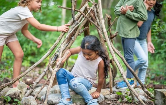 enfants qui ont construit une cabane en foret