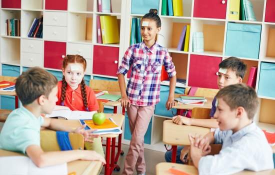 enfants en classe qui jouent à devine tete